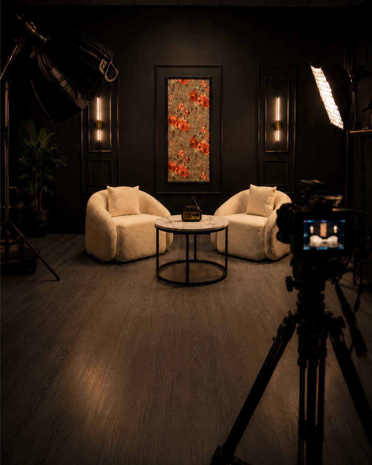 Décor lounge du studio Shootnes avec fauteuils crème et caméra sur trépied